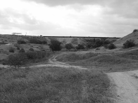 מבט על הגשר מצפון. נראית גם סוללת העפר ששימשה באופן זמני למעבר הרכבת. מצד שמאל דגל ישראל. זאת האנדרטה לסיירת שקד.